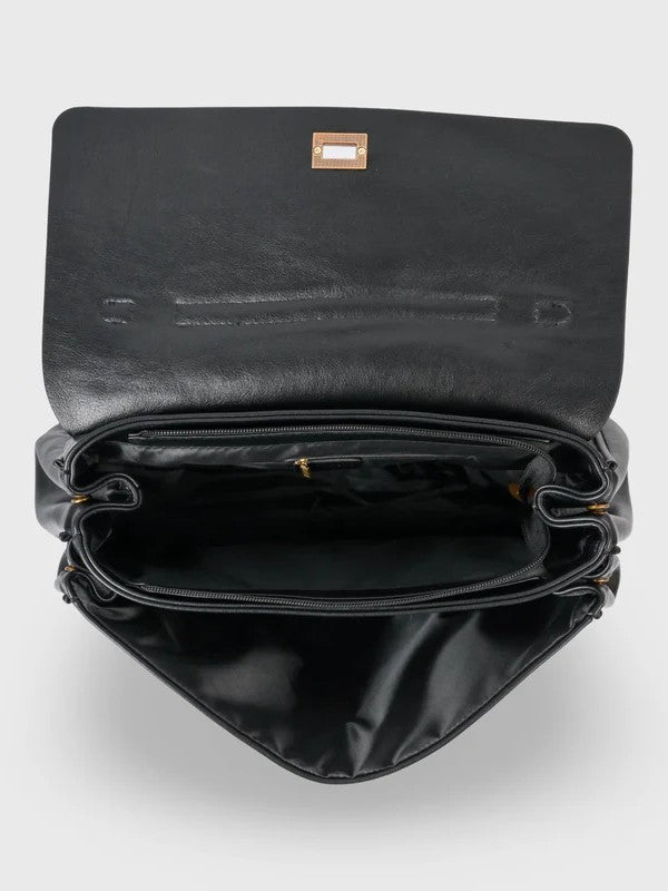 Black leather shoulder bag with structured shape, flap closure and slim top handle, photographed on a light background