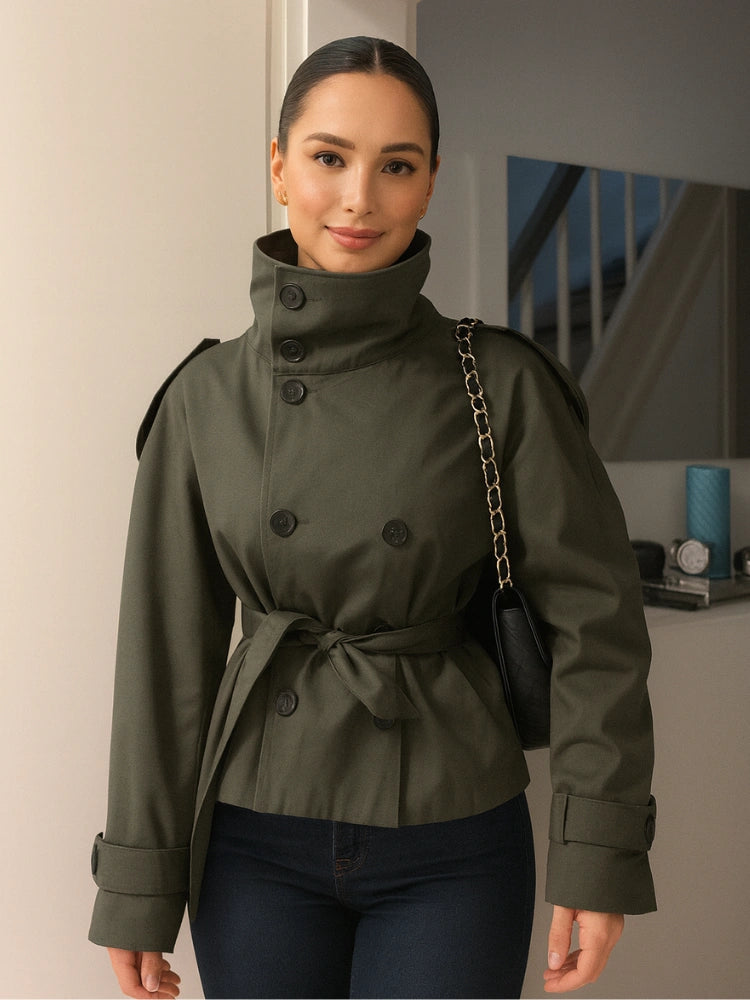 trench coat for women with a structured fit, high collar and dark buttons. Crafted from premium fabric, it highlights the waist and adds refined elegance to any autumn or winter outfit.