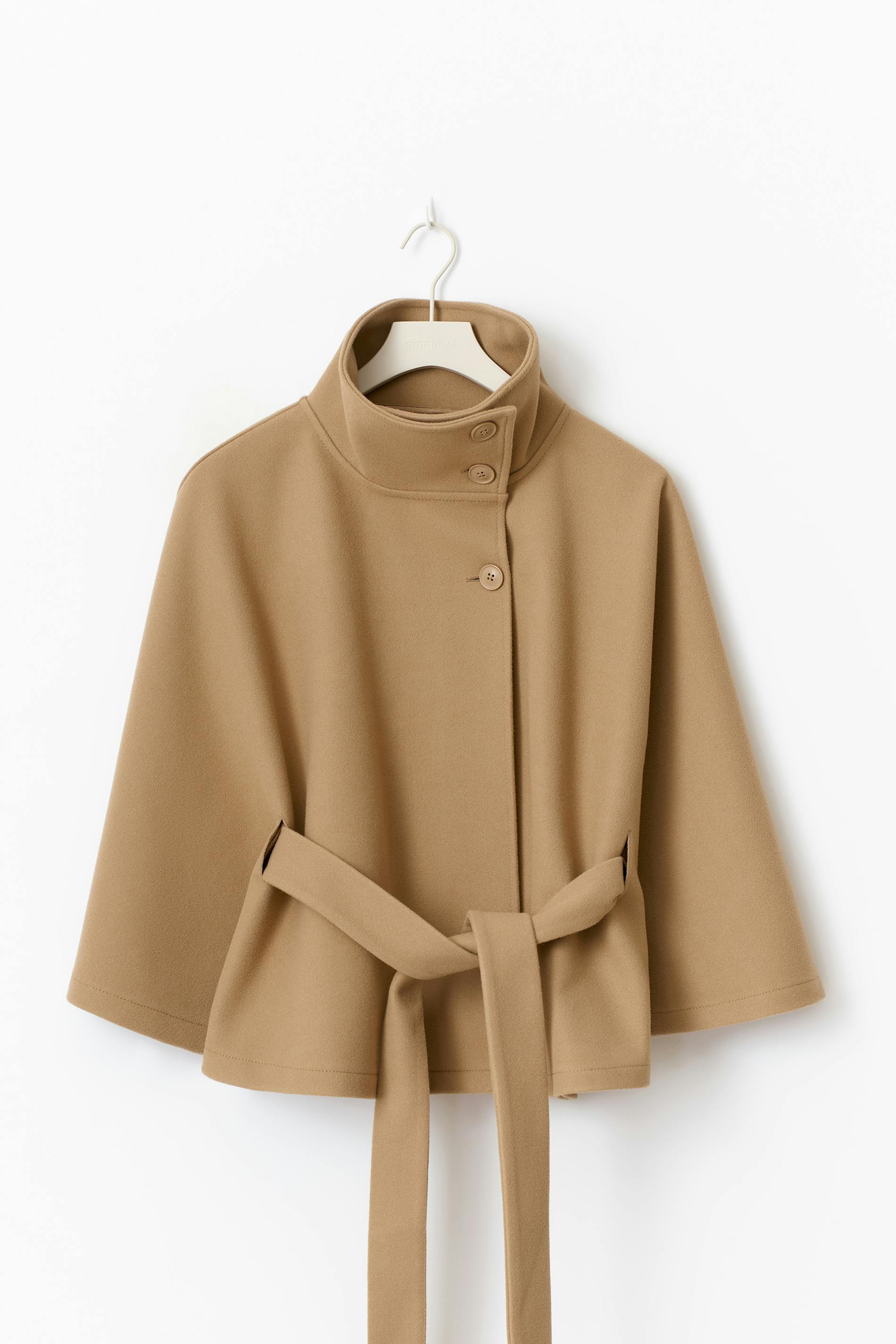 winter coat with high-neck collar, cape silhouette and adjustable waist belt. A chic belted jacket combining elegance, comfort and versatile seasonal style.