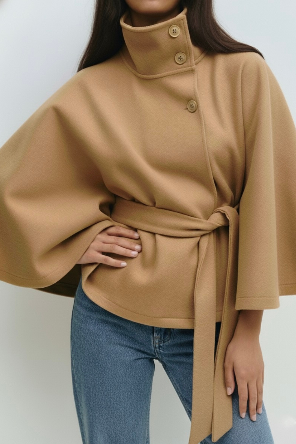winter coat with high-neck collar, cape silhouette and adjustable waist belt. A chic belted jacket combining elegance, comfort and versatile seasonal style.