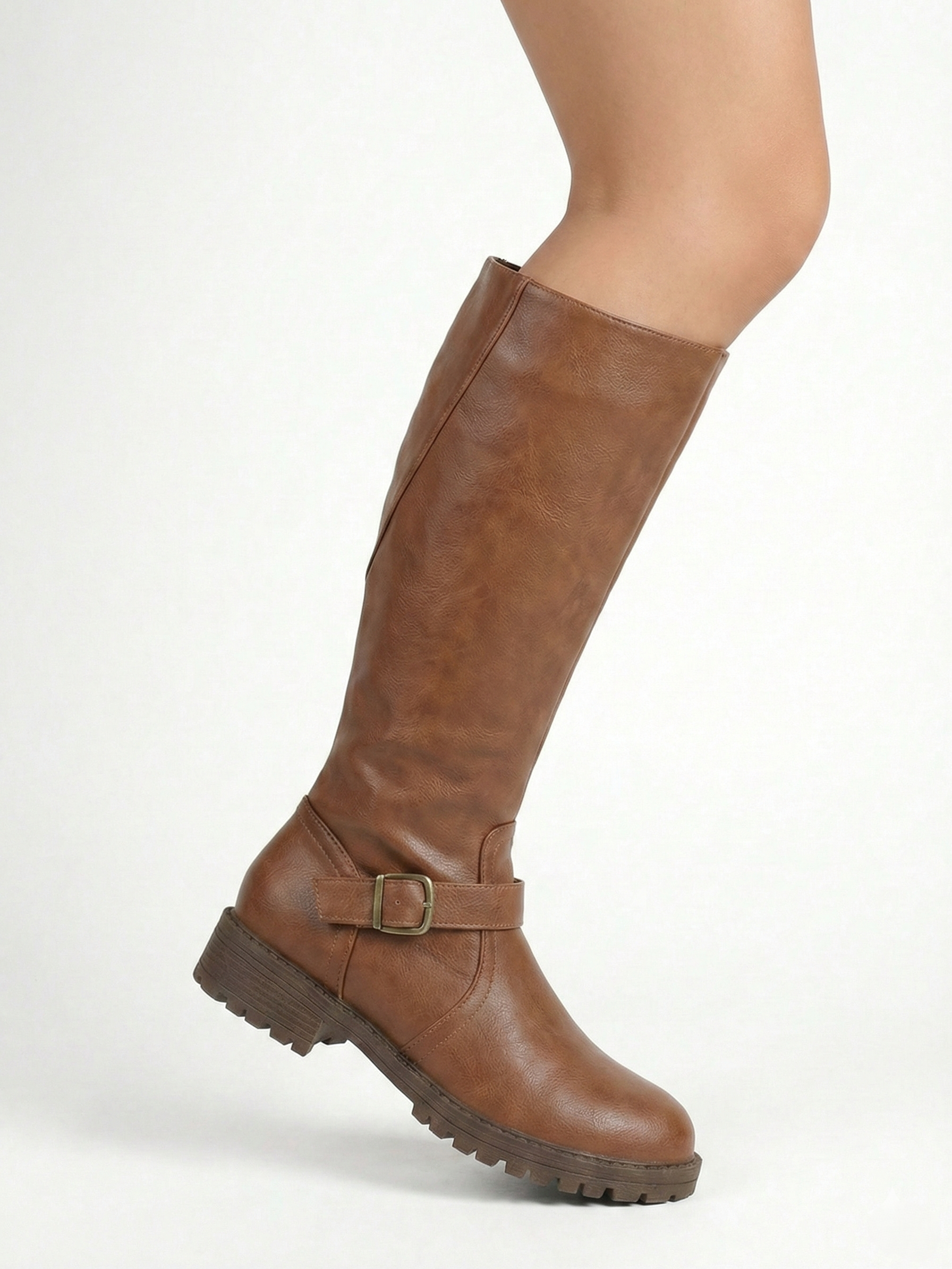 Brown knee-high leather-look boot with side buckle strap, round toe and chunky tread sole, minimalist studio white background.
