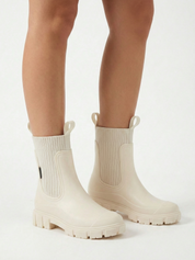 White waterproof ankle boot with elastic side panels, pull tabs and chunky lug sole