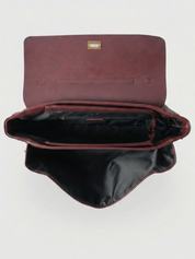 Burgundy leather shoulder bag with structured shape, flap closure and slim top handle, photographed on a light background