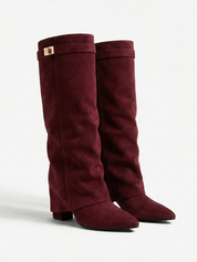 Burgundy knee-high boot with a smooth suede-like finish, pointed toe, discreet low block heel, straight shaft design, and a slim metallic buckle detail at the top.