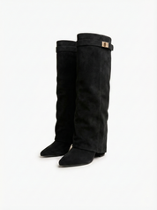 Black knee-high boot with a smooth suede-like finish, pointed toe, discreet low block heel, straight shaft design, and a slim metallic buckle detail at the top.