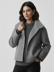 Black high-neck jacket with asymmetrical buttons and structured silhouette, featuring wide sleeves and a minimalist design for modern everyday styling.