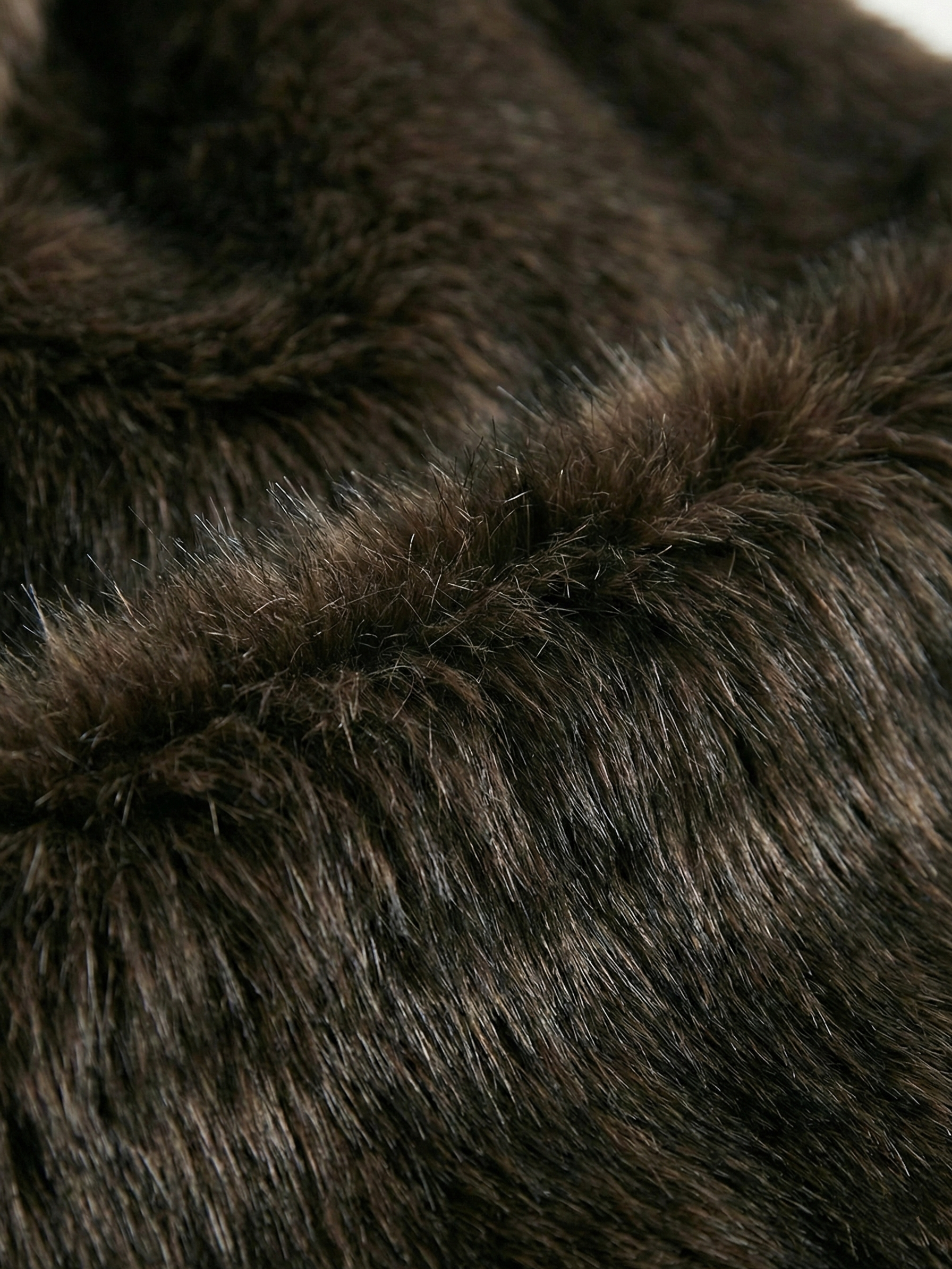 Long faux fur coat in deep brown tones with wide lapel collar and full-length silhouette