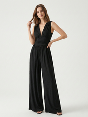 Black sleeveless jumpsuit with deep V neckline, ruched waist and wide-leg trousers