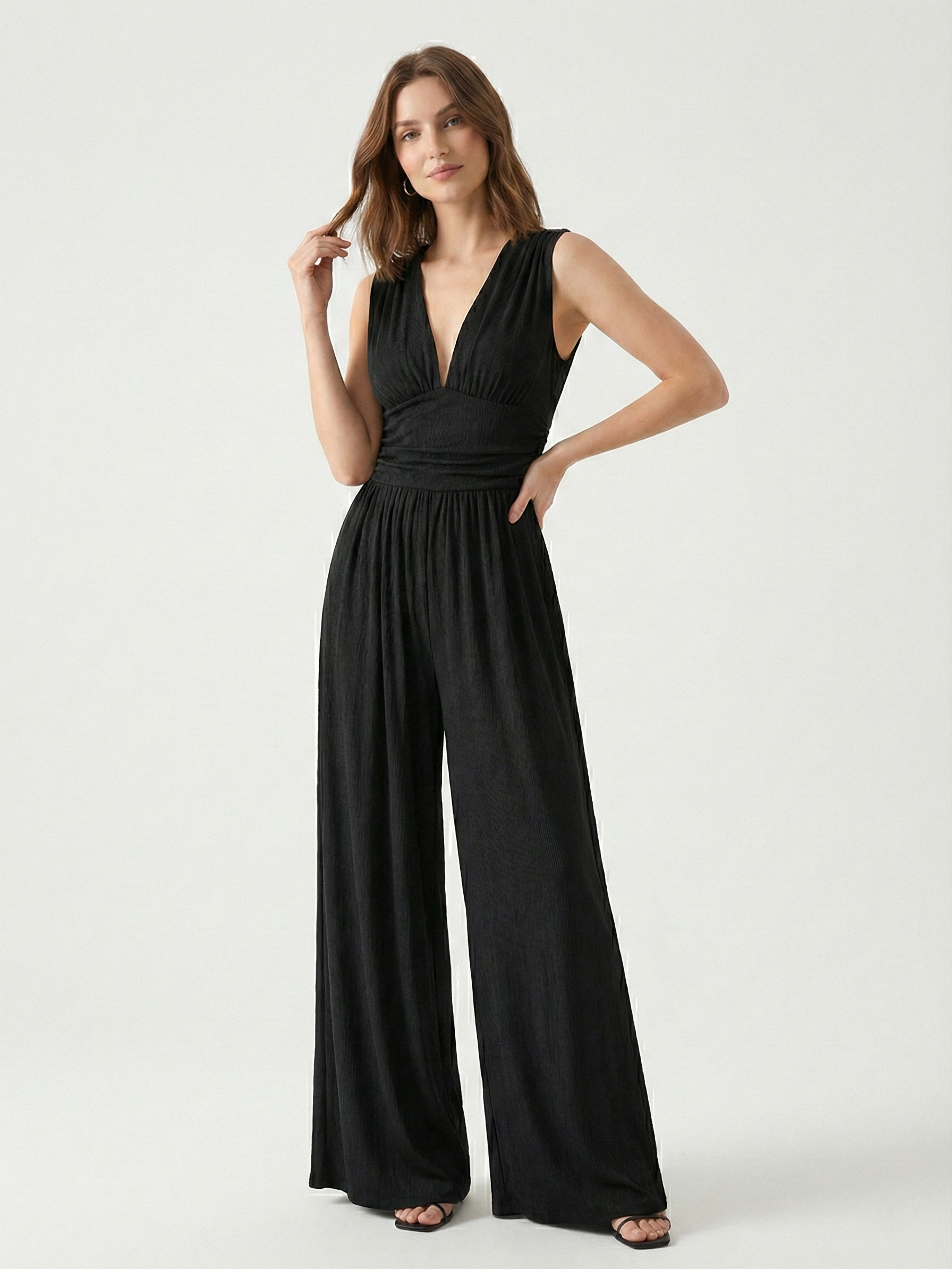 Black sleeveless jumpsuit with deep V neckline, ruched waist and wide-leg trousers