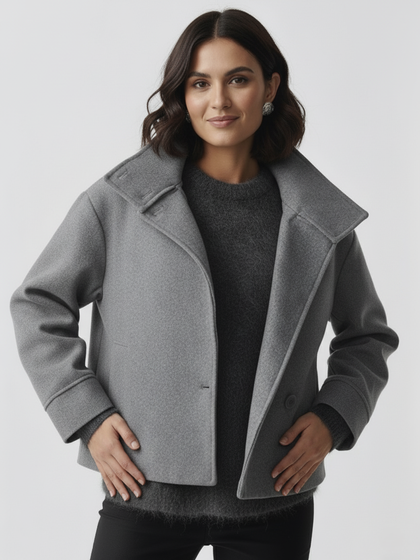 Black high-neck jacket with asymmetrical buttons and structured silhouette, featuring wide sleeves and a minimalist design for modern everyday styling.