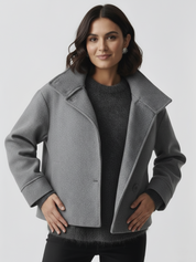 Black high-neck jacket with asymmetrical buttons and structured silhouette, featuring wide sleeves and a minimalist design for modern everyday styling.