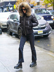 Black puffer jacket with padded quilted design and a plush faux fur hood. Features zip fastening, fitted waist and long sleeves, offering warmth and stylish winter protection.