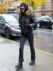 Black puffer jacket with padded quilted design and a plush faux fur hood. Features zip fastening, fitted waist and long sleeves, offering warmth and stylish winter protection.