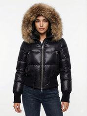 Black puffer jacket with padded quilted design and a plush faux fur hood. Features zip fastening, fitted waist and long sleeves, offering warmth and stylish winter protection.