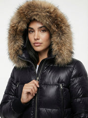 Black puffer jacket with padded quilted design and a plush faux fur hood. Features zip fastening, fitted waist and long sleeves, offering warmth and stylish winter protection.