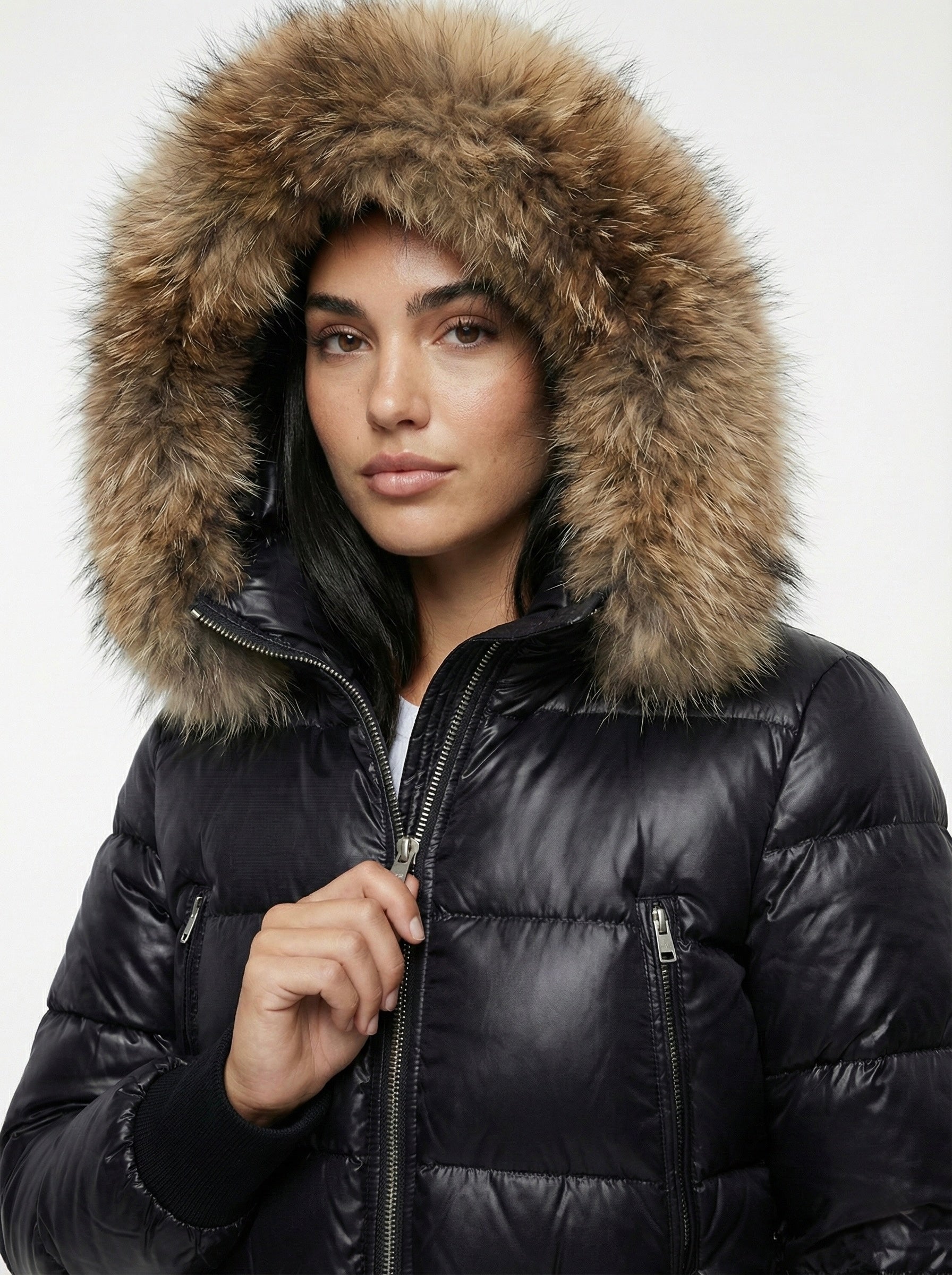 Black puffer jacket with padded quilted design and a plush faux fur hood. Features zip fastening, fitted waist and long sleeves, offering warmth and stylish winter protection.