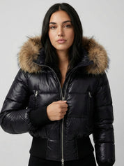 Black puffer jacket with padded quilted design and a plush faux fur hood. Features zip fastening, fitted waist and long sleeves, offering warmth and stylish winter protection.
