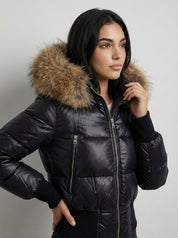 Black puffer jacket with padded quilted design and a plush faux fur hood. Features zip fastening, fitted waist and long sleeves, offering warmth and stylish winter protection.