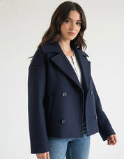 Navy double-breasted short jacket featuring a structured fit, wide lapel collar and clean tailoring. A versatile women’s jacket ideal for autumn and winter everyday wear.