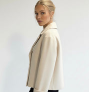 Navy double-breasted short jacket featuring a structured fit, wide lapel collar and clean tailoring. A versatile women’s jacket ideal for autumn and winter everyday wear.