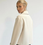 Navy double-breasted short jacket featuring a structured fit, wide lapel collar and clean tailoring. A versatile women’s jacket ideal for autumn and winter everyday wear.