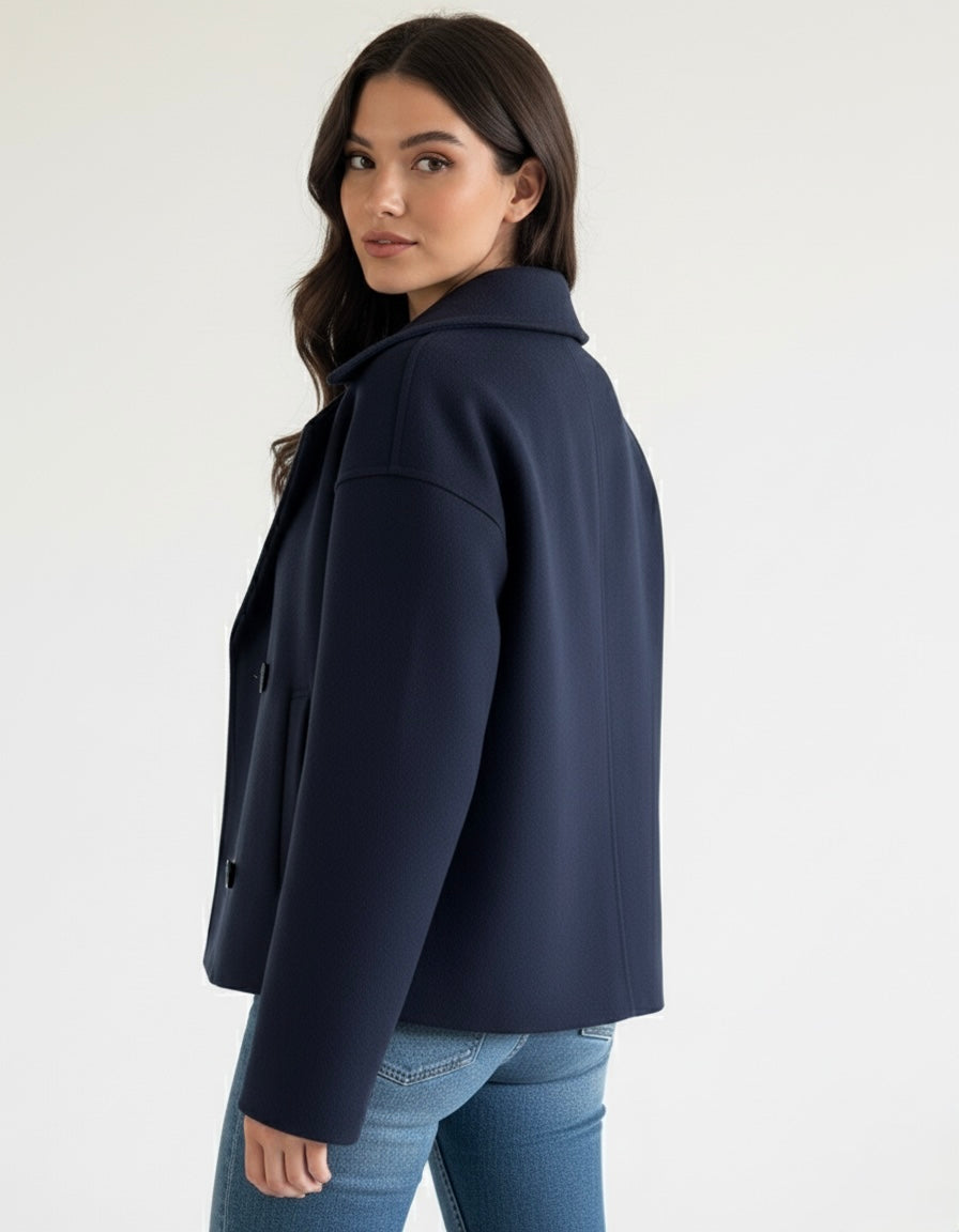 Navy double-breasted short jacket featuring a structured fit, wide lapel collar and clean tailoring. A versatile women’s jacket ideal for autumn and winter everyday wear.