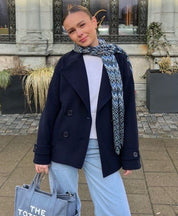 Navy double-breasted short jacket featuring a structured fit, wide lapel collar and clean tailoring. A versatile women’s jacket ideal for autumn and winter everyday wear.